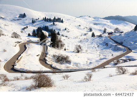 Mountain road with curves in winter season 64472437