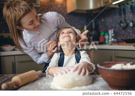 Woman cooking and having fun with little girl Woman cooking and having fun with little girl 64472556