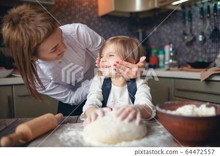 Woman cooking and having fun with little girl 64472557