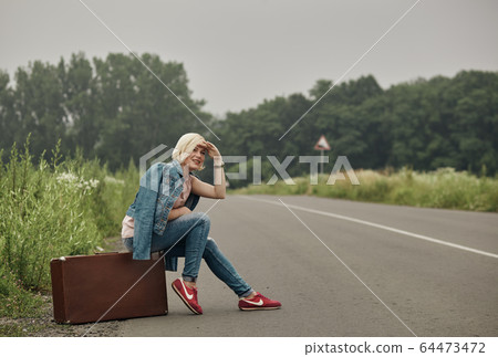 Traveler girl on the road. Concept of travel, vacation, solo-female tourism, travel, adventure. 64473472