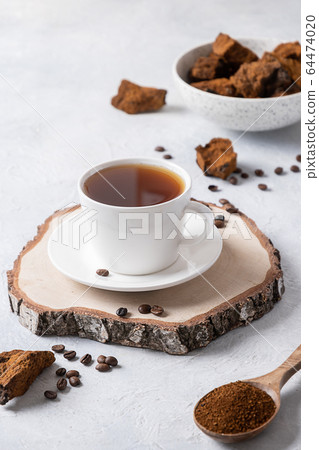 Chaga infusion beverage in cup. Close up. 64474020