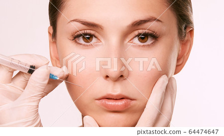 Face female injection. Doctor hand near beauty portrait. Salon toxin procedure Face female injection. Doctor hand near beauty portrait. Salon toxin procedure 64474647