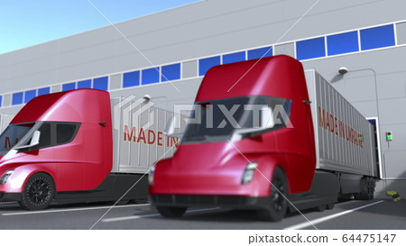 Modern semi-trailer trucks with MADE IN UKRAINE text being loaded or unloaded at warehouse. Ukrainian business related 3D rendering 64475147