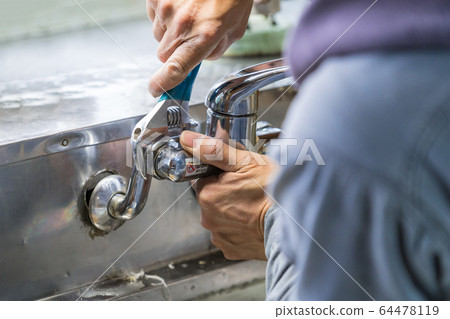 Plumber installing a faucet waterworks Plumber installing a faucet waterworks 64478119