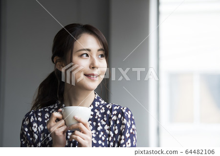 Young woman drinking coffee Young woman drinking coffee 64482106