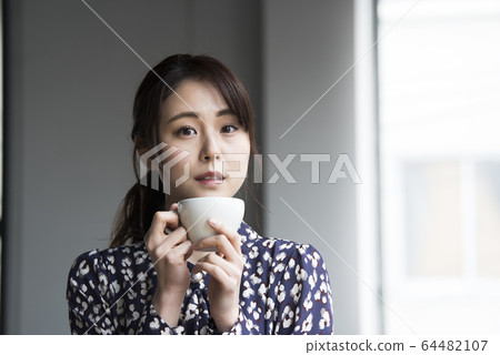 Young woman drinking coffee 64482107