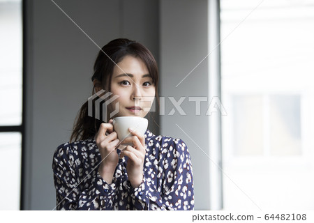 Young woman drinking coffee 64482108