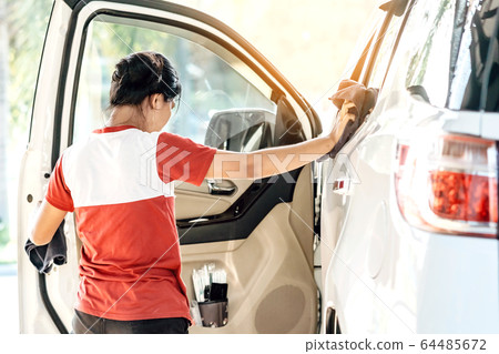 Woman cleaning with a blowers and microfiber wipe the car polishing after car wash. Woman cleaning with a blowers and microfiber wipe the car polishing after car wash. 64485672