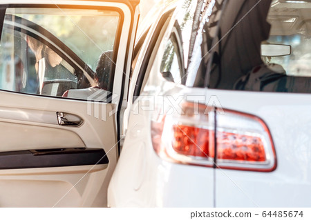 Woman cleaning with a blowers and microfiber wipe the car polishing after car wash. Woman cleaning with a blowers and microfiber wipe the car polishing after car wash. 64485674