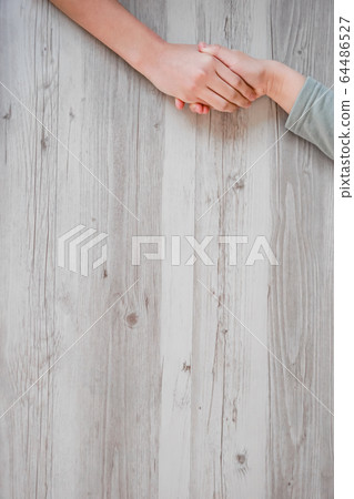 Child holding hands on the table Child holding hands on the table 64486527