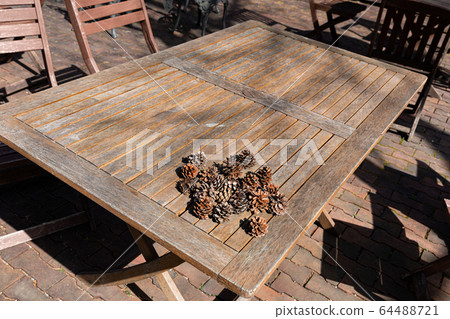 Wood table and pine cones on the terrace 64488721