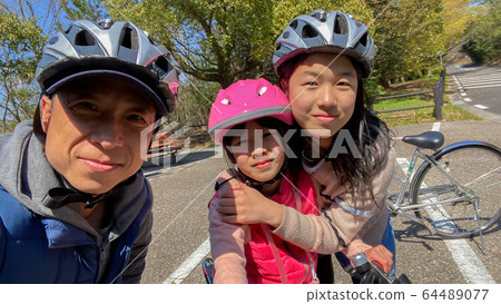 Family riding bicycles in spring park - Stock Photo [64489077] - PIXTA
