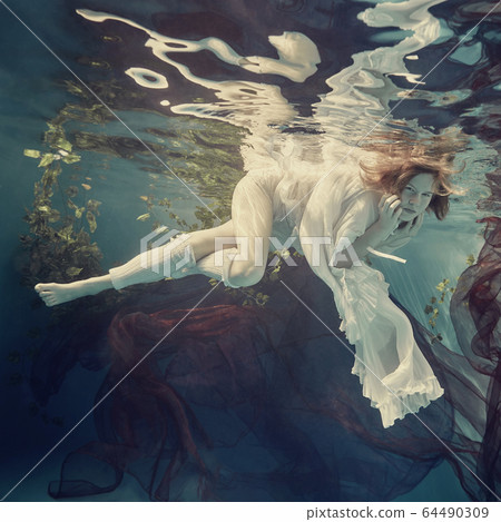 Portrait of a girl floating underwater 64490309