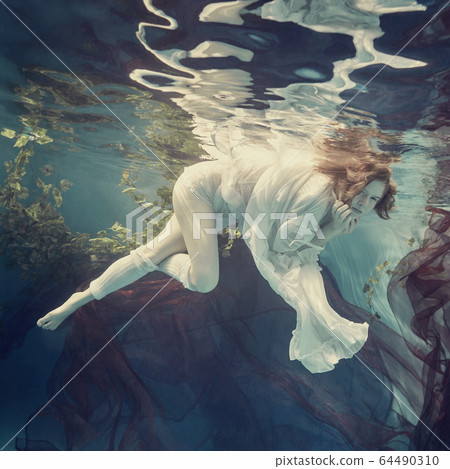 Portrait of a girl floating underwater Portrait of a girl floating underwater 64490310
