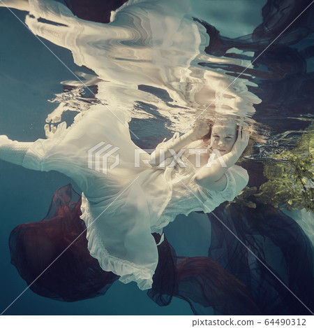 Portrait of a girl floating underwater Portrait of a girl floating underwater 64490312