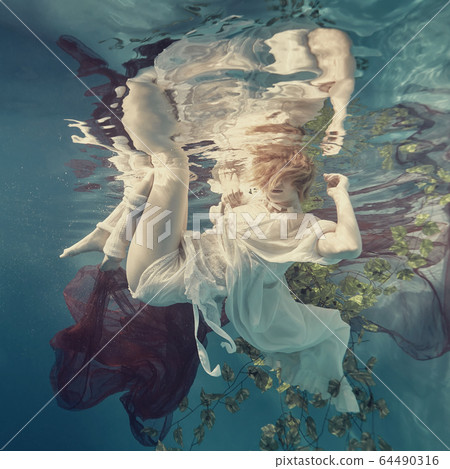 Portrait of a girl floating underwater 64490316