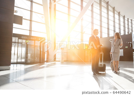 Businessman discussing plans with businesswoman in 64490642
