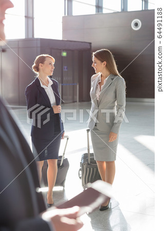 Businesswomen discussing plans while walking with 64491188