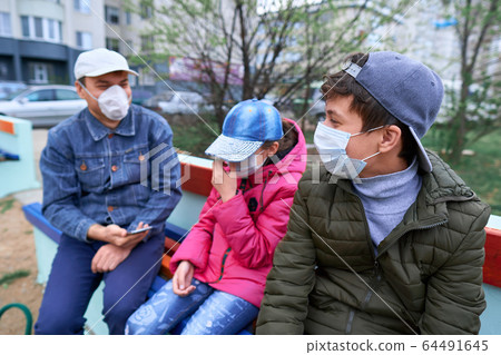 father and children sitting on a bench on father and children sitting on a bench on 64491645