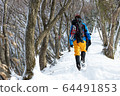 Climbing a snowy mountain 64491853