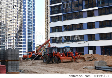 Auto crane and tractors at a construction site 64493125