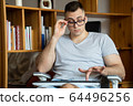 The quarantined guy works remotely from home. Communication, people and freelance work concept 64496256