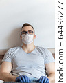 The quarantined guy works remotely from the hospital. Communication, people and freelance work concept 64496277
