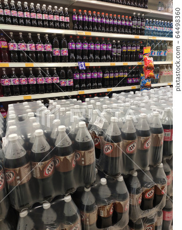 KUALA LUMPUR, MALAYSIA -MARCH 16, 2020: Soft drinks or carbonated drinks arranged and stacked on the rack inside the huge supermarket for sale. Sorted by the brand to make easy for the customer to buy KUALA LUMPUR, MALAYSIA -MARCH 16, 2020: Soft drinks or carbonated drinks arranged and stacked on the rack inside the huge supermarket for sale. Sorted by the brand to make easy for the customer to buy 64498360
