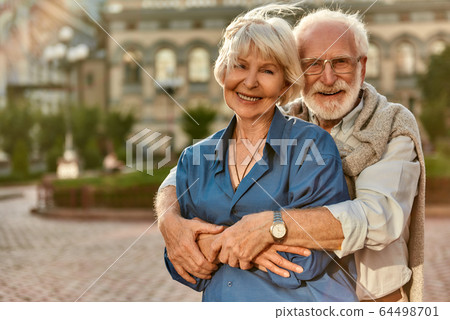Let the love last forever. Happy senior couple bonding to each other and smiling while sitting on the park bench together Let the love last forever. Happy senior couple bonding to each other and smiling while sitting on the park bench together 64498701