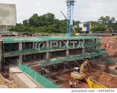 The construction site is operating during the day. Workers are busy carrying out their activities as planned under the supervisor's supervision. The construction site is operating during the day. Workers are busy carrying out their activities as planned under the supervisor's supervision. 64498938