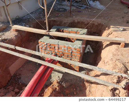 Utility services manhole under construction at the construction site. In-situ construction by workers based on infrastructure engineer design. 64499217