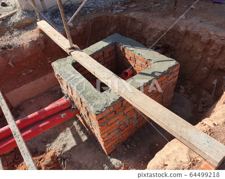 Utility services manhole under construction at the construction site. In-situ construction by workers based on infrastructure engineer design. 64499218