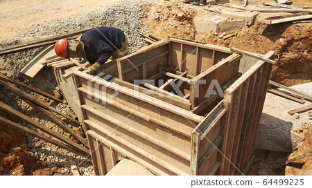Utility services manhole under construction at the construction site. In-situ construction by workers based on infrastructure engineer design. Utility services manhole under construction at the construction site. In-situ construction by workers based on infrastructure engineer design. 64499225