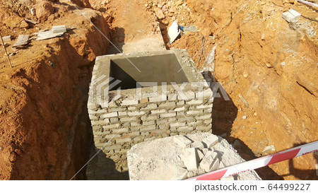 Utility services manhole under construction at the construction site. In-situ construction by workers based on infrastructure engineer design. 64499227