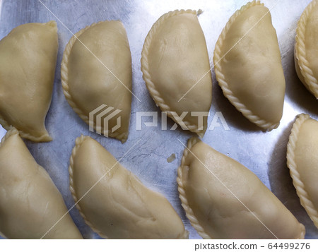 Curry puffs for sale. It is one of the traditional cakes in Malaysia. Skin made from the wheat flour mixture and the inside is potato and curry mixture. Curry puffs for sale. It is one of the traditional cakes in Malaysia. Skin made from the wheat flour mixture and the inside is potato and curry mixture. 64499276
