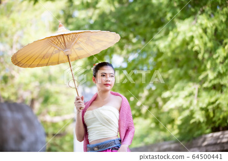 Portrait of an Asian Women in Thai Lanna and Shan Traditional Clothes are Standing and hold umbrella Against Thailand Temple Portrait of an Asian Women in Thai Lanna and Shan Traditional Clothes are Standing and hold umbrella Against Thailand Temple 64500441