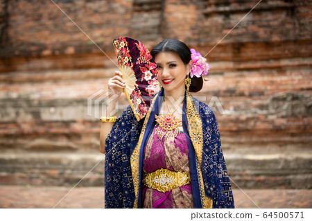 Indonesia Young beautiful woman with Traditional dress standing and look at camera at Gate to heaven Handara Golf Gate in Bedugul, Bali ,Indonesia. 64500571