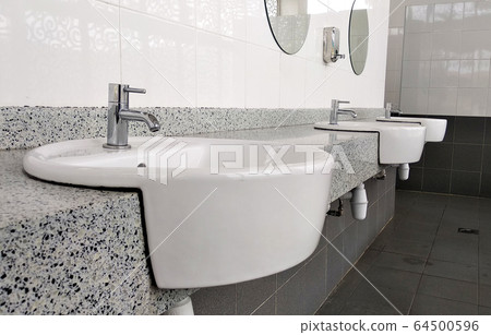 Public toilet counter top complete with basins, water taps, and face mirror. Arranged in one line for public use. Public toilet counter top complete with basins, water taps, and face mirror. Arranged in one line for public use. 64500596