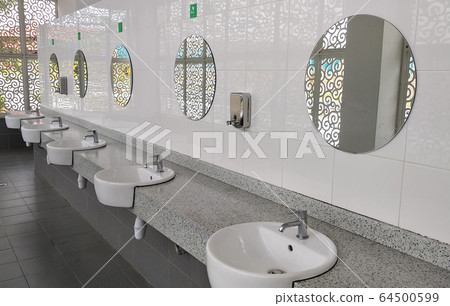 Public toilet counter top complete with basins, water taps, and face mirror. Arranged in one line for public use. Public toilet counter top complete with basins, water taps, and face mirror. Arranged in one line for public use. 64500599