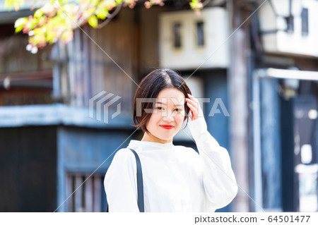 A woman sightseeing the streets of Kyoto 64501477