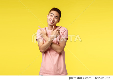 Silly and cute asian man in pink t-shirt smiling sween and caring, tilt head lovely as pointing sideways to both good variants, pointing left and right, showing two choices, stand yellow background Silly and cute asian man in pink t-shirt smiling sween and caring, tilt head lovely as pointing sideways to both good variants, pointing left and right, showing two choices, stand yellow background 64504086