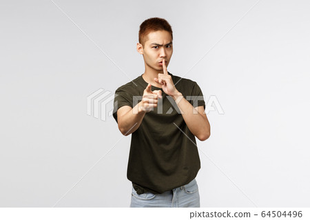 You better keep mouth shut. Portrait of angry serious-looking asian man pointing at camera and shushing scolding you for being noisy and loud, tell person be quiet and dont speek, grey background You better keep mouth shut. Portrait of angry serious-looking asian man pointing at camera and shushing scolding you for being noisy and loud, tell person be quiet and dont speek, grey background 64504496
