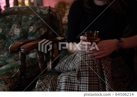 Hand of woman drinking coffee in cafe 64506214