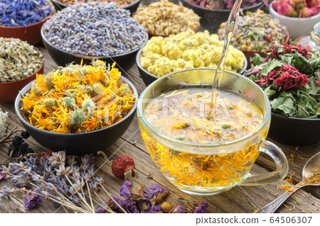 Calendula tea poured into cup. Medicinal herbs. Calendula tea poured into cup. Medicinal herbs. 64506307