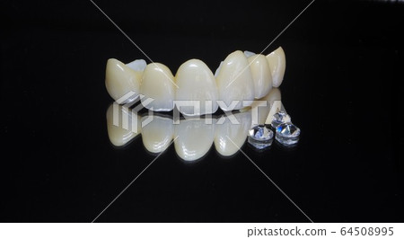 Have a beautiful white ceramic tooth by a dentist and welcome the new year with a smile 64508995