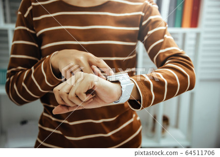 Female accountant looking time at hand watches in 64511706