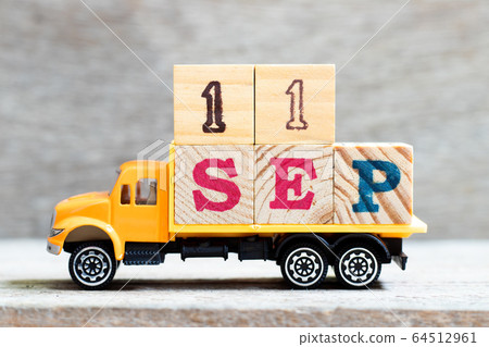 Truck hold letter block in word 11sep on wood background Truck hold letter block in word 11sep on wood background 64512961