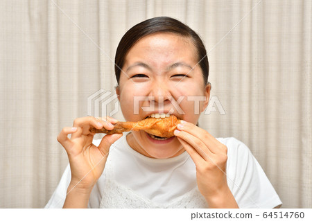 Girl eating fried chicken Girl eating fried chicken 64514760