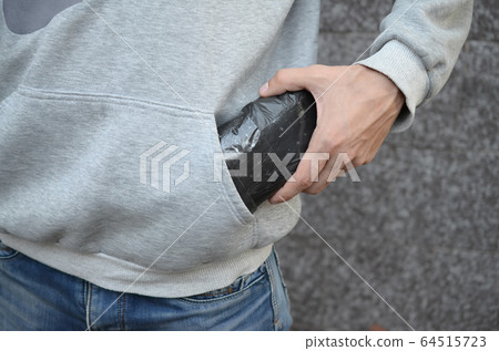 Drug dealer taking bag with cocaine out of hoodie Drug dealer taking bag with cocaine out of hoodie 64515723