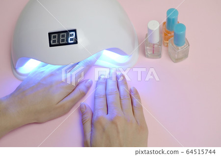Hands of young woman at manicure procedure close Hands of young woman at manicure procedure close 64515744